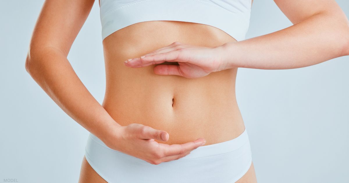 Woman with hands around stomach (MODEL)